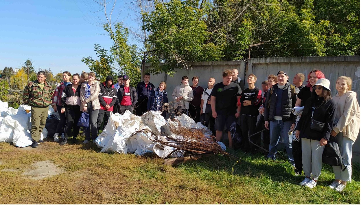 Группа волонтёров с мешками собранного мусора